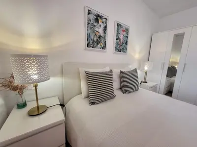 a white bedroom with a bed with two pillows at Vale Formoso Apartment in Porto