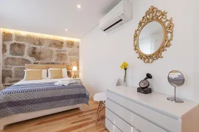 a bedroom with a bed and a mirror at Sendme2Portugal: Loureiro in Porto