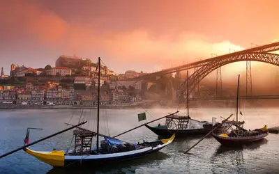 three boats in the water in front of a bridge at O'Porto Cheers Gaia in Vila Nova de Gaia