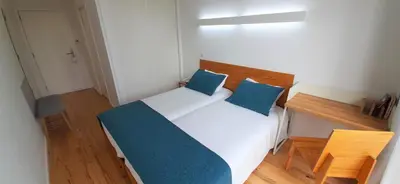 a bedroom with a bed with two blue pillows at Boavista Class Inn in Porto