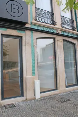 a building with two large glass doors on a street at Boavista Class Inn in Porto