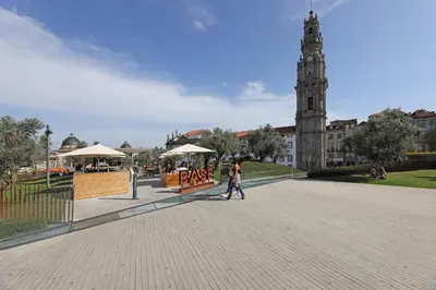 a couple of people walking down a street with a clock tower at FLH Porto Comfort Flat in Porto