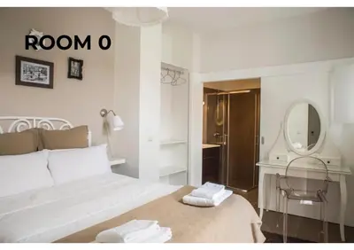 a white bedroom with a bed and a mirror at BCharming House in Porto