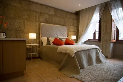 a bedroom with a bed and a stone wall at Turra Residence in Porto