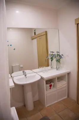 a white bathroom with a sink and a mirror at Turra Residence in Porto