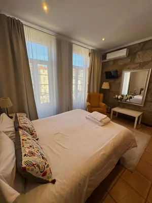 a bedroom with a large white bed and a chair at Turra Residence in Porto