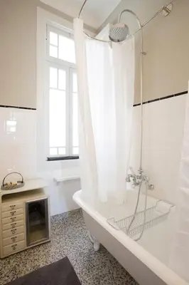 a white bathroom with a tub and a window at 14º Esquadra — Cais das Pedras Guest House in Porto