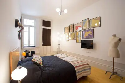 a bedroom with a bed and a tv on the wall at 14º Esquadra — Cais das Pedras Guest House in Porto