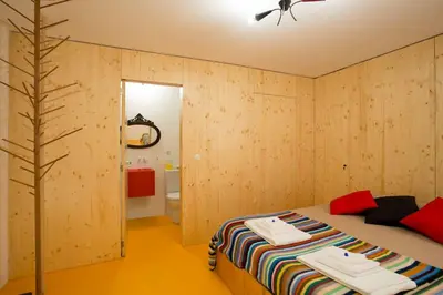 a bedroom with wooden walls and a bed with towels on it at 14º Esquadra — Cais das Pedras Guest House in Porto