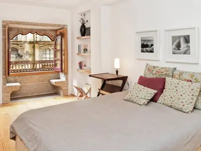 a bedroom with a large bed and a mirror at Flowerstreet54 in Porto