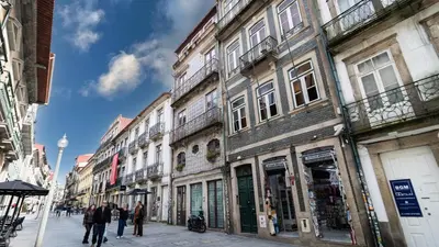a street with tables and an umbrella in front of a building at Flowerstreet54 in Porto