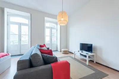 a living room with a couch and a tv at GuestReady - Clérigos Virtudes Apartments in Porto