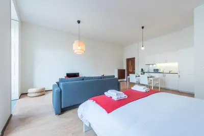 a bedroom with a large bed and a blue couch at GuestReady - Clérigos Virtudes Apartments in Porto