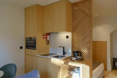 a small kitchen with wooden cabinets and a refrigerator at N Apartments - Chã in Porto