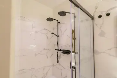 a bathroom with a shower with white marble at N Apartments - Chã in Porto