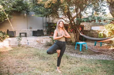 a woman doing a yoga pose in front of a tree at Urban Garden Porto Central Hostel in Porto