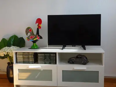 a white entertainment center with a flat screen tv on it at Bom dia Porto in Vila Nova de Gaia