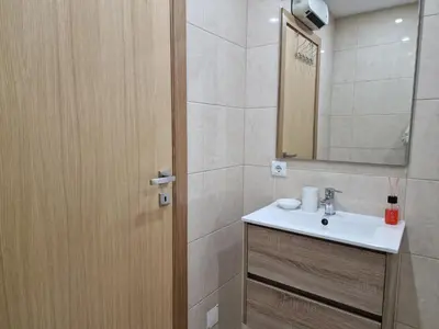 a bathroom with a sink and a mirror and a door at Cozy Apartment with Terrace, Air Cond, Free Parking, by Porto with Love LDA in Porto