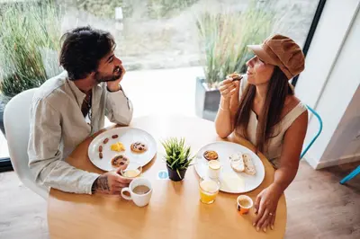 a man and woman sitting at a table eating food at Stay Hotel Porto Centro Trindade in Porto