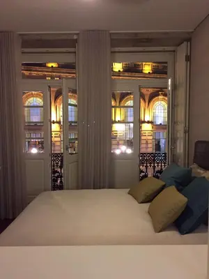 a bedroom with a large white bed with windows at São Bento Front Homy Studio in Porto
