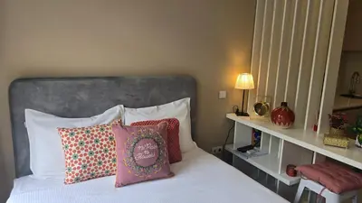 a bedroom with a bed with a gray headboard and pillows at São Bento Front Homy Studio in Porto