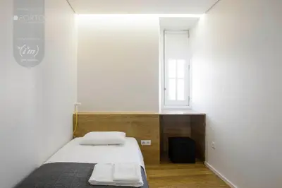 a bedroom with a bed with two towels on it at ORM - Saraiva de Carvalho Apartments in Porto