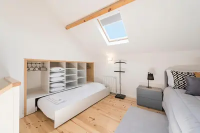 a living room with a white couch and a window at LovelyStay-Modern Loft City Center in Porto