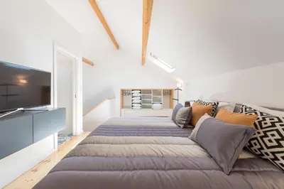 a bedroom with a large bed and a couch at LovelyStay-Modern Loft City Center in Porto