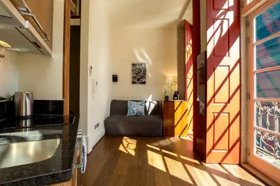 a kitchen and living room with a couch in a room at Flores Lofts in Porto