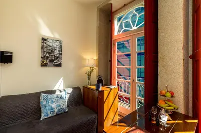 a living room with a couch and a window at Flores Lofts in Porto