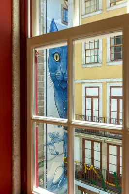 a window with a painting of a blue cat at Flores Lofts in Porto