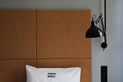 a bed with a lamp and a white pillow at Porto Music Guest House in Porto