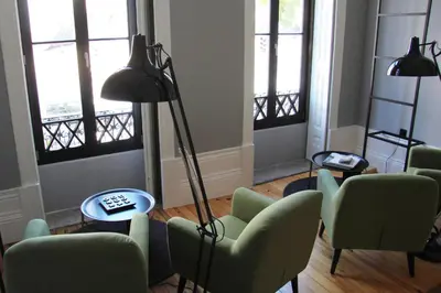 a living room with chairs and a lamp and windows at Porto Music Guest House in Porto