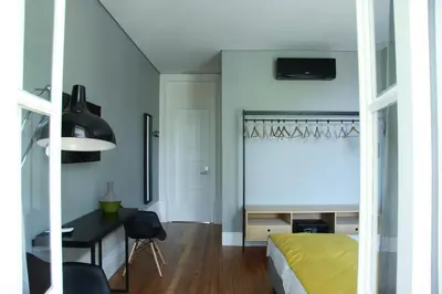 a bedroom with a bed and a desk and a window at Porto Music Guest House in Porto