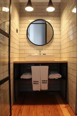 a bathroom with a sink and a mirror and towels at Porto Music Guest House in Porto