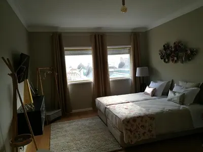 a bedroom with a large bed and a window at Pontocom Bolhão Apartment in Porto
