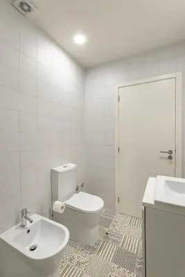 a white bathroom with a toilet and a sink at Charming Balcony Apartment in Historic Ribeira - Inside Porto Apartments 
