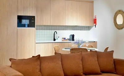 a living room with a couch and a kitchen at Oporto Coliseum Residence in Porto