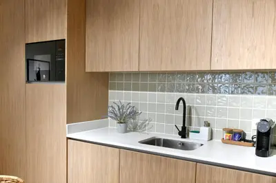 a kitchen with a sink and wooden cabinets at Oporto Coliseum Residence in Porto