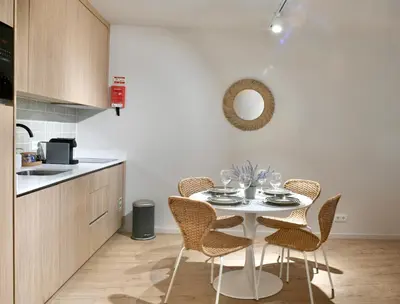 a kitchen with a white table and chairs in a room at Oporto Coliseum Residence in Porto