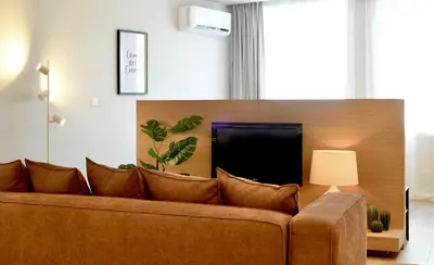 a living room with a couch and a tv at Oporto Coliseum Residence in Porto