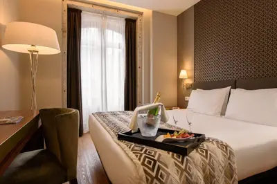 a hotel room with a bed with a tray of food on it at Exe Almada Porto in Porto