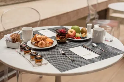 a table with chairs and a plate of food on it at Exe Almada Porto in Porto