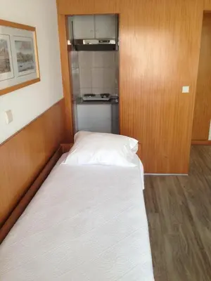 a bed in a small room with a kitchen at Seculo apartments in Porto