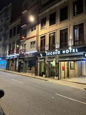 a building with a hotel sign on the side of a street at Seculo apartments in Porto