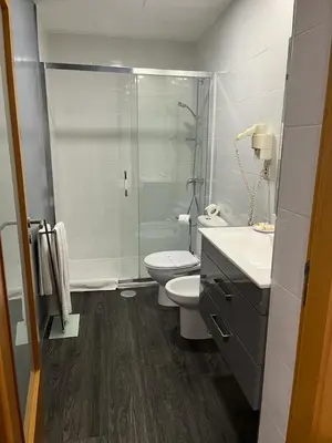 a bathroom with a shower and a toilet and a sink at Seculo apartments in Porto