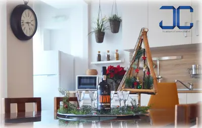 a table with a bottle of wine and a christmas tree at Country Apartment by JC in Porto