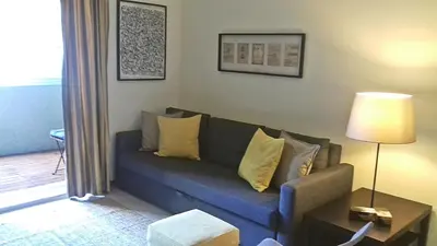 a living room with a blue couch with yellow pillows at Bombarda House & Home in Porto