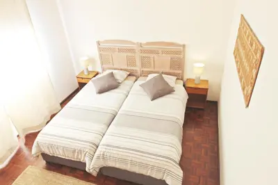 a large bed in a room with two lamps at Bombarda House & Home in Porto
