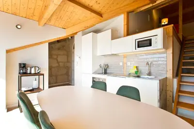 a kitchen and dining room with a white table and chairs at RVA - Sao Joao Novo Apartments in Porto